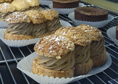 Plusieurs desserts choux café dans la vitrine du restaurant "Les Délices du Cotentin" à Sainte mere église.