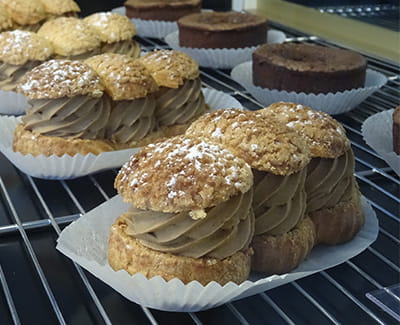 Plusieurs desserts choux café dans la vitrine du restaurant "Les Délices du Cotentin" à Sainte mere église.